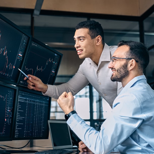 Colegas de trabalho a olhar para gráficos em monitores